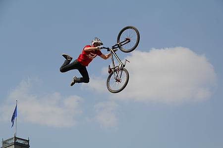 man doing tricks in BMX bike in mid-air during daytime thumbnail
