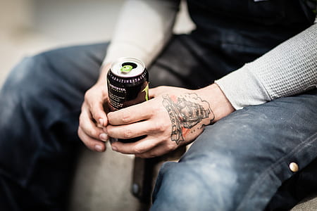 person holding opened black can thumbnail