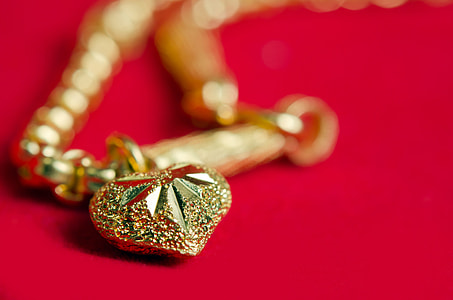 gold-colored chain heart pendant necklace close-up photo thumbnail