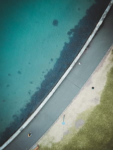 aerial photography of concrete road beside body of water thumbnail