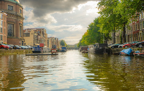 canal between houses and cars during daytime thumbnail