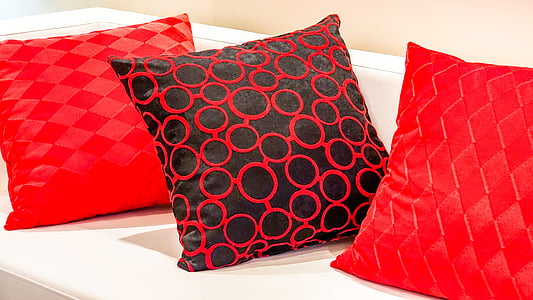 three red throw pillows on white sofa thumbnail