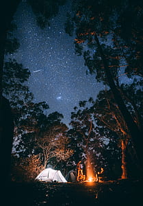 group of people in front of fire beside whit tent thumbnail