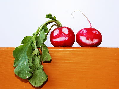 two round red raddishes on brown painted shelf thumbnail