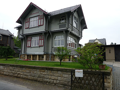 gray and black wooden 2-storey house under gray clouds thumbnail