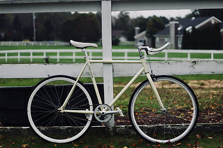 white bike near white wooden fence thumbnail