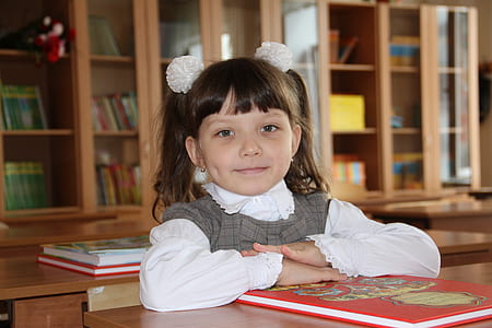 smiling girl sitting inside library thumbnail
