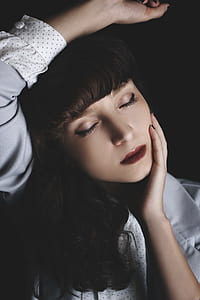 woman closing her eyes with hand on her chin thumbnail