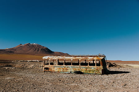 gray abandon bus on sand during daytime thumbnail