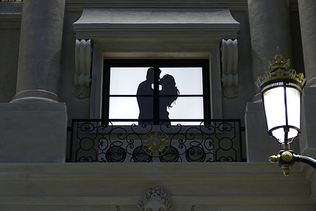 silhouette of man and woman kissing near window thumbnail