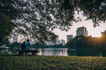 two person sitting near body of water at daytime thumbnail