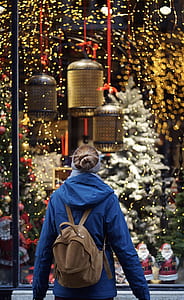woman with backpack walking near christmas decors thumbnail