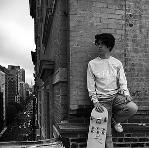 man leaning on wall holding skateboard thumbnail