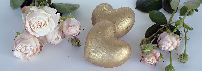 two heart gold decors beside pink petaled flowers thumbnail