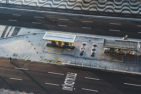 bird's-eye view photography of gray steel roof between asphalt road thumbnail