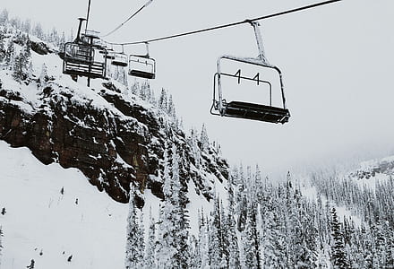gray and black cable cars near trees covered with snow thumbnail