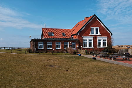 red house surrounded by green grass thumbnail