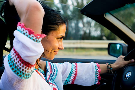 woman driving BMW convertible on road thumbnail