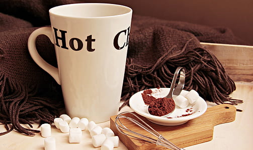 white and black ceramic mug near brown textile thumbnail