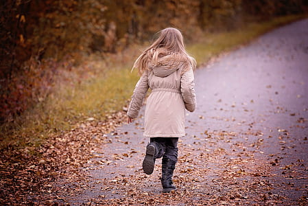 girl wearing beige hoodie running on road during daytime thumbnail