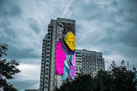 white concrete building under white clouds near green leaf tree at daytime thumbnail