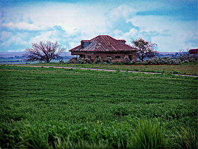 brown wooden house in front of green grass field thumbnail
