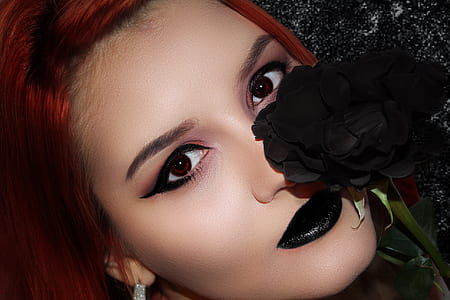 woman's face beside black petaled flower thumbnail