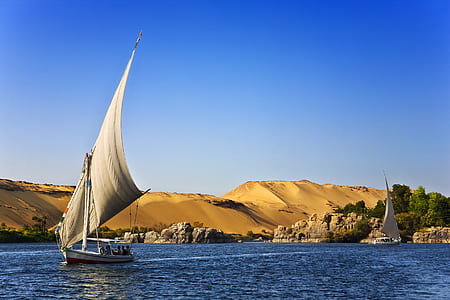 two sailboats in water with desert nearby thumbnail