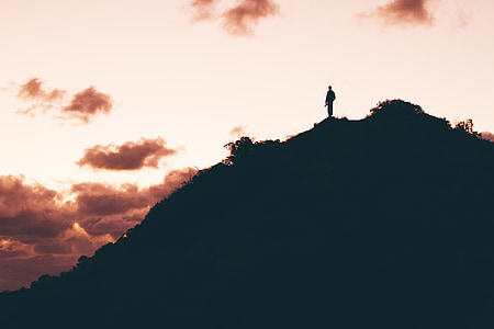 silhouette of person standing on top of hill thumbnail