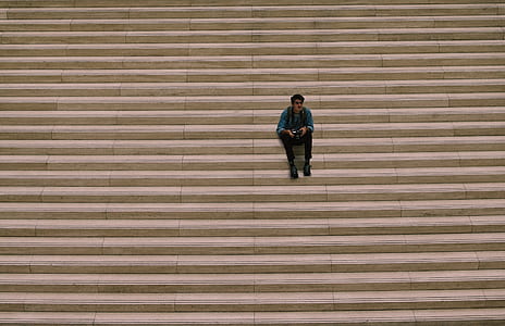 man sitting on staircase during daytime thumbnail