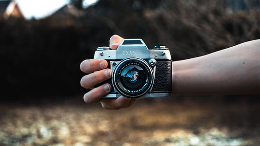 person holding black and gray SLR camera thumbnail