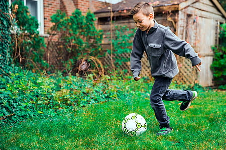 Young Boy Kicking Ball Photo thumbnail