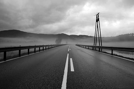 asphalt road under cloudy sky during daytime thumbnail