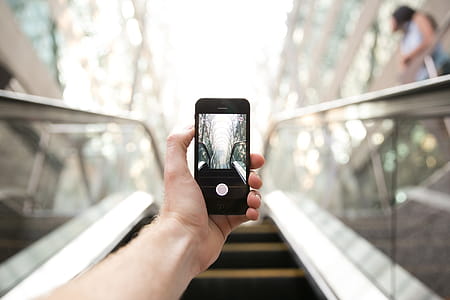 Photography on an escalator with mobile phone held in left hand thumbnail