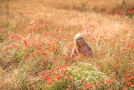 woman sitting in red poppy field at daytime thumbnail