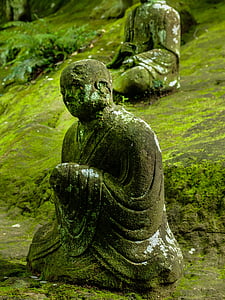 sitting monk statue with algae during daytime thumbnail