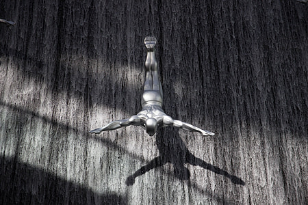 grayscale photo of man doing stunt with heads down and wide arms open thumbnail