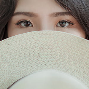 Person Covering Face With Hat Photo thumbnail