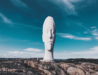 human face statue on top of rocky mountain thumbnail