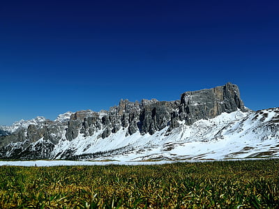 landscape photo of green grass field near rock mountain thumbnail