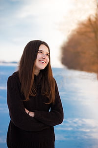 smiling woman standing beside body of water thumbnail