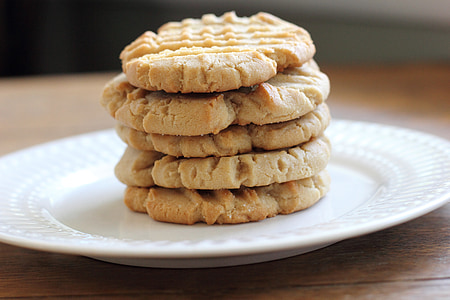 stacked five baked cookies on white ceramic plate selective focus photo thumbnail