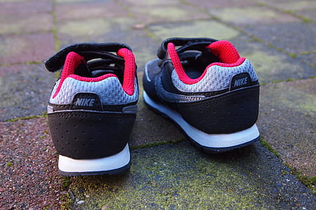 selective focus photography of black-gray-white-and-red Nike low-top sneakers on brick surface thumbnail