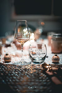 tilt shift lens photography of wine glass beside gold bauble thumbnail