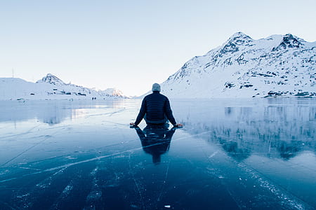 man sitting near snow covered mountain during daytime thumbnail