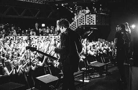 man standing on stage playing guitar thumbnail