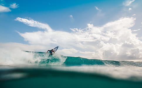 surfer surfing on wave during daytime thumbnail