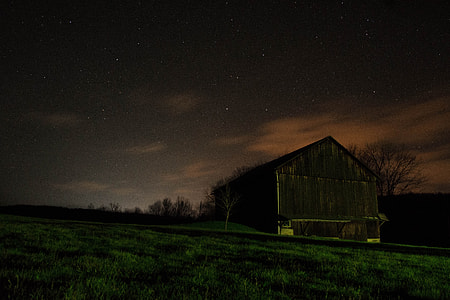 silhouette photo of brown house near grass field thumbnail