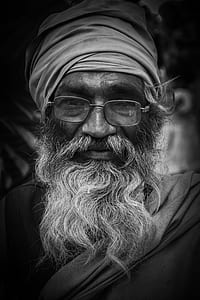 grayscale closeup photo of man wearing fabric headwear and eyeglasses thumbnail