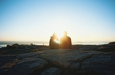silhouette of two person seating looking at the sunrise thumbnail